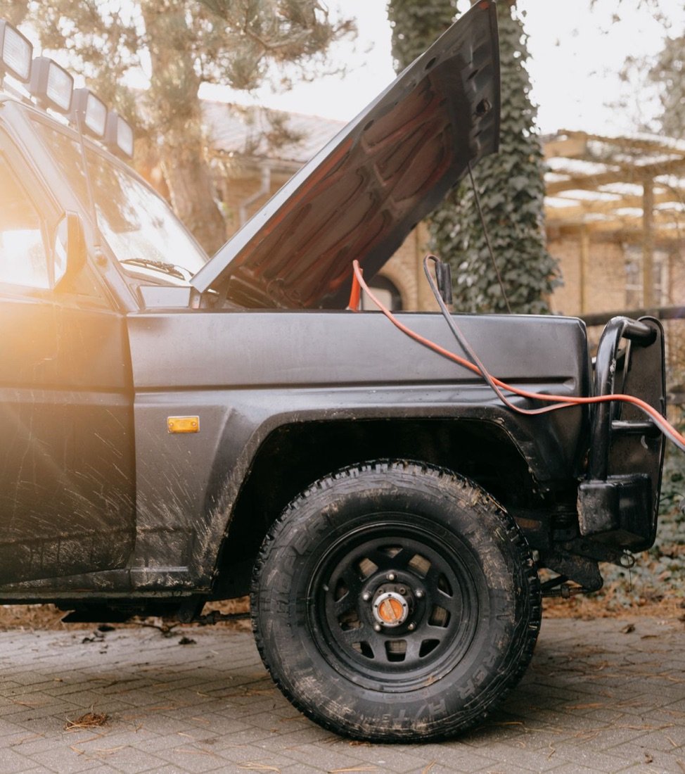 Jump-starting a vehicle with the hood raised on the roadside